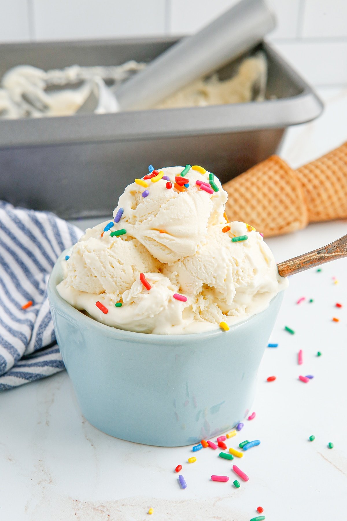 Made with just 4 ingredients, this is the best Homemade Vanilla Ice Cream. It's soft, creamy, and requires no churning! A blue bowl of vanilla cream with sprinkles
