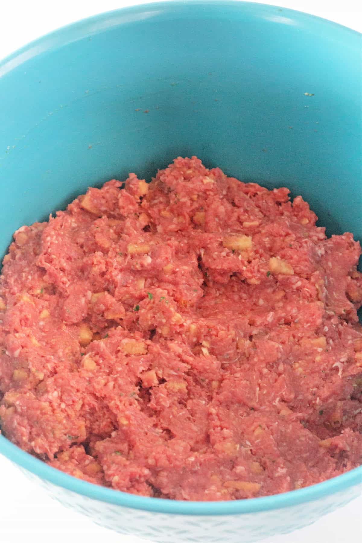 Ground beef and stuffing mix combined in a bowl to create the meatloaf mixture.